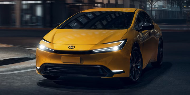 2026 Toyota Prius in vibrant yellow driving at night.