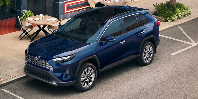 2026 Navy Blue Toyota RAV4 parked in front of cafe 