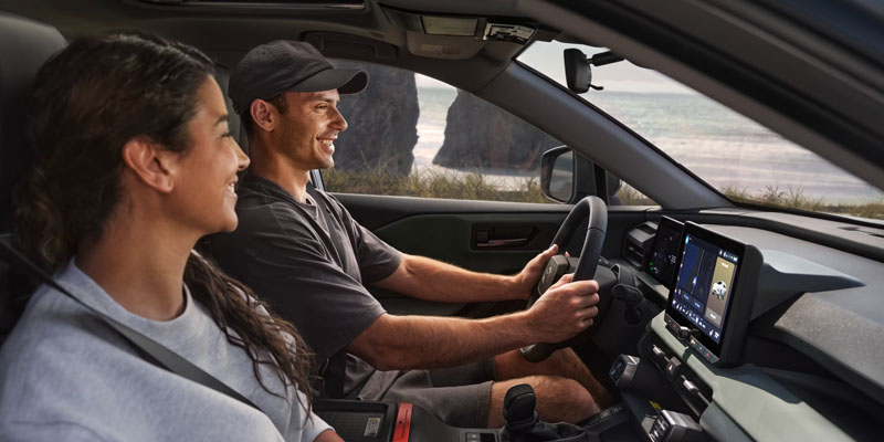 Passengers enjoying a drive inside a modern Toyota vehicle with touchscreen technology.